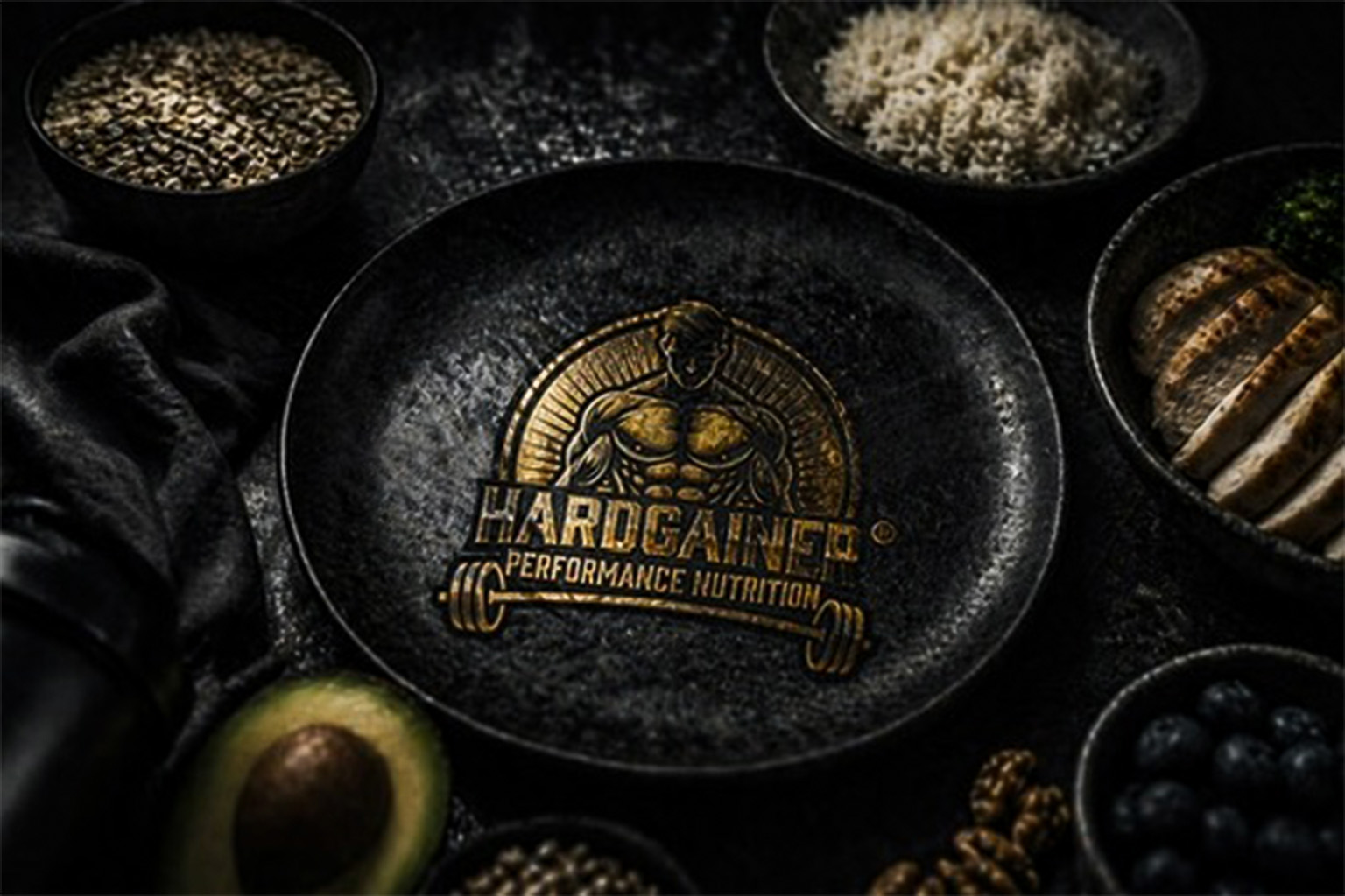 Hardgainer Performance Nutrition Logo auf schwarzem Teller umgeben von Hähnchenbrust Blaubeeren Avocado Reis und Samen als Symbol für strukturierte Hardgainer Ernährung
